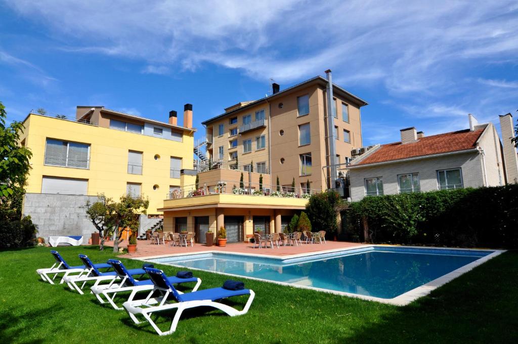 um quintal com cadeiras e uma piscina e um edifício em Aparthotel Solé em Pobla de Segur