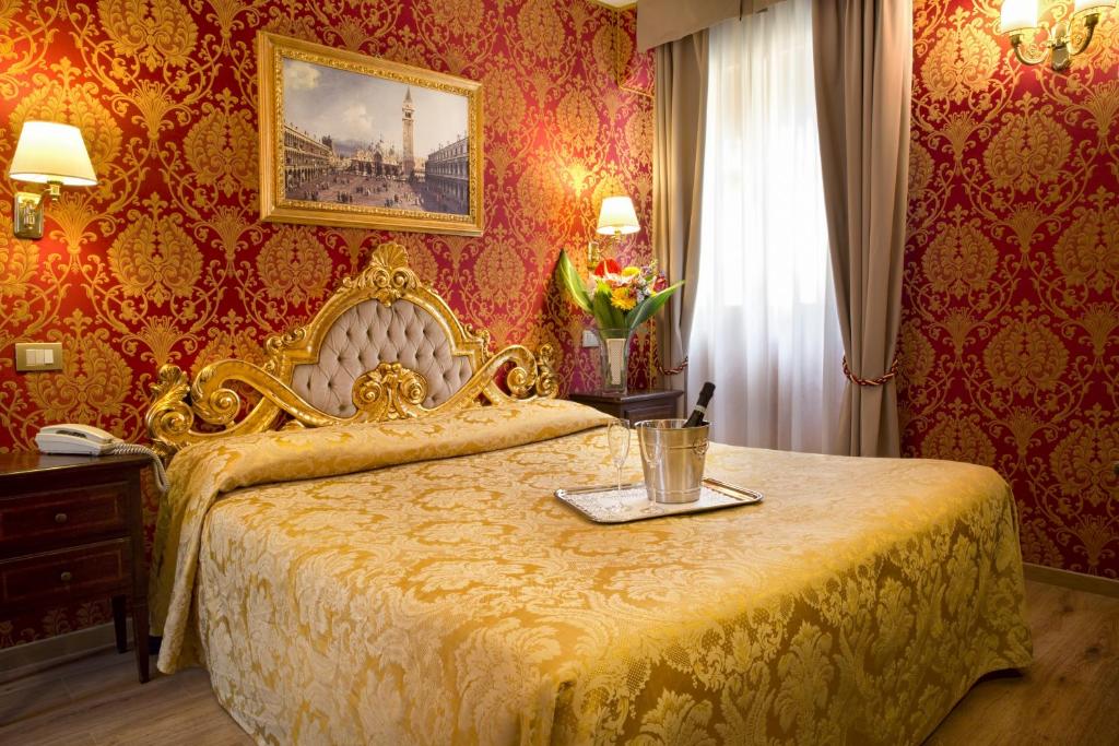 a bedroom with a gold bed with a tray on it at Residenza Goldoni in Venice