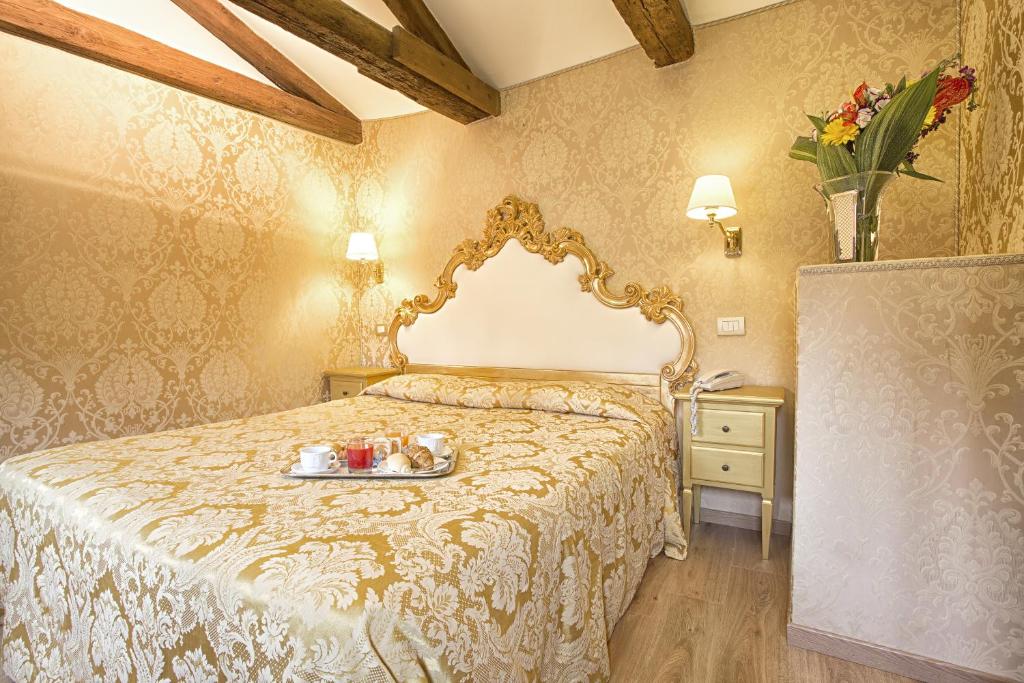 a bedroom with a bed with a tray of food on it at Residenza Goldoni in Venice