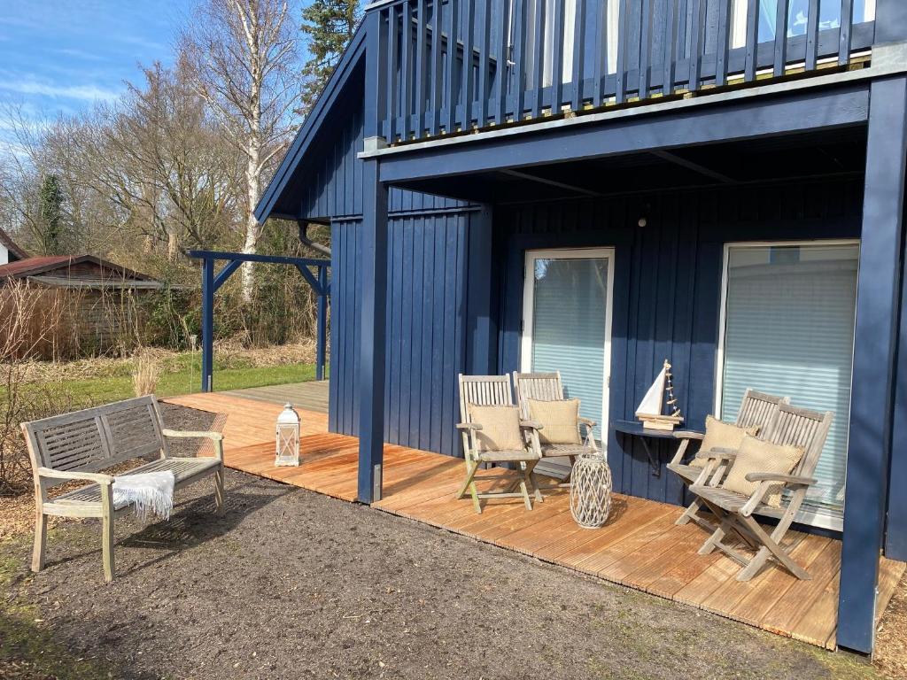 eine Terrasse mit Stühlen und einer Bank auf einem Haus in der Unterkunft Villa Gudrun, luxury Beach House in Zingst