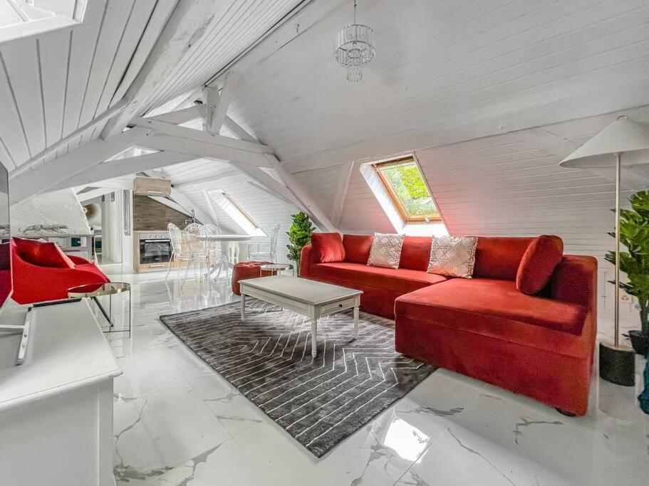 ein Wohnzimmer mit einem roten Sofa und einem Tisch in der Unterkunft Loft apartment in the Castle Château du Châtelard in Montreux