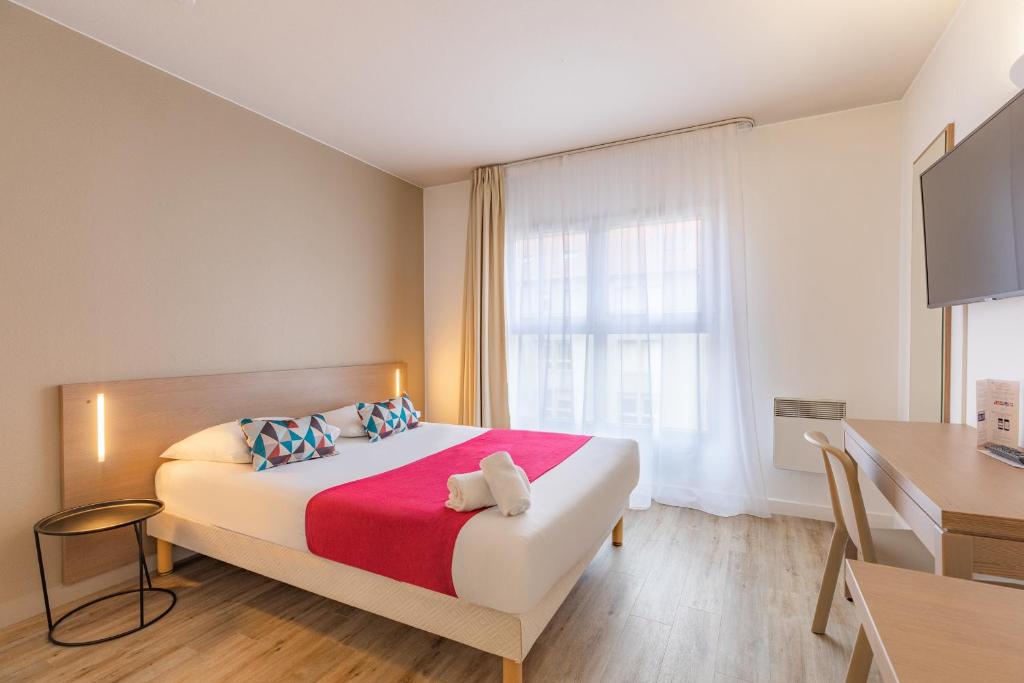 Dormitorio con cama, escritorio y TV en Appart'City Classic Lyon Part Dieu Villette en Lyon