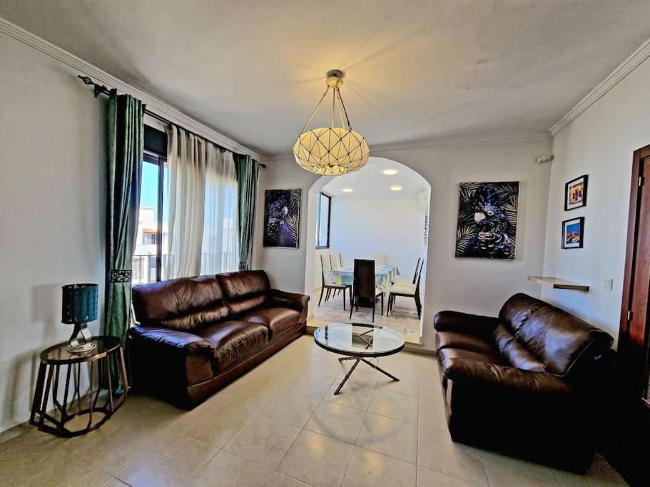オランにあるF4 résidence hasnaouiのリビングルーム(革張りのソファ、テーブル付)