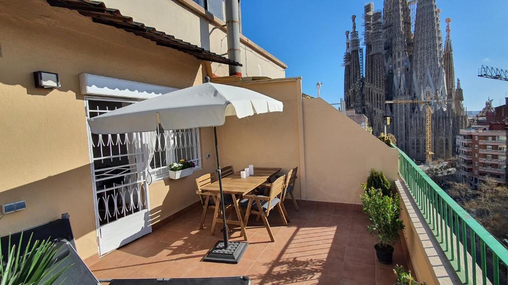 a patio with a table and an umbrella on a building at Opening Doors Sagrada Familia in Barcelona