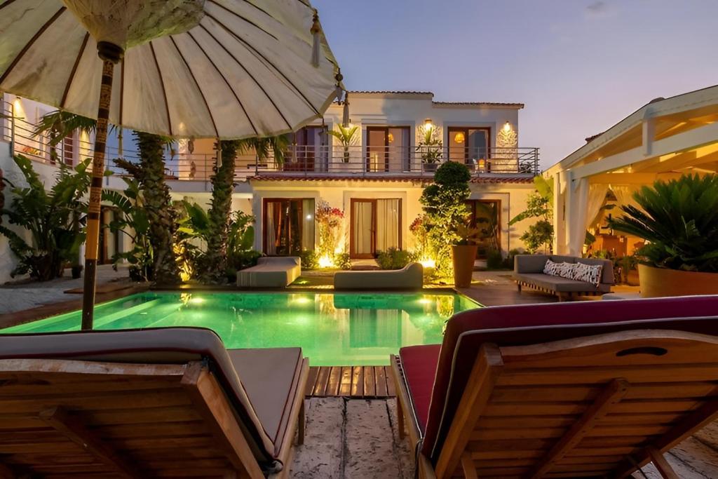 a house with a swimming pool with an umbrella at 777 Alaçatı Adults only in Alacati