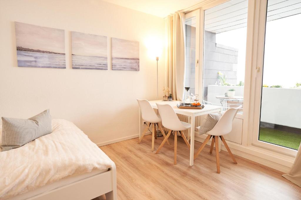 Pokój ze stołem i krzesłami oraz sypialnią w obiekcie Gemütliches und helles Studio Apartment mit Balkon, Badewanne, WLAN, Parkplatz w Bremie