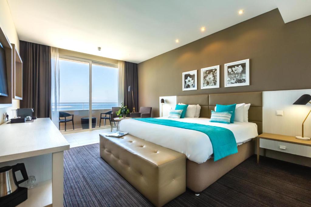 Habitación de hotel con cama grande y escritorio. en Salini Resort, en St Paul's Bay