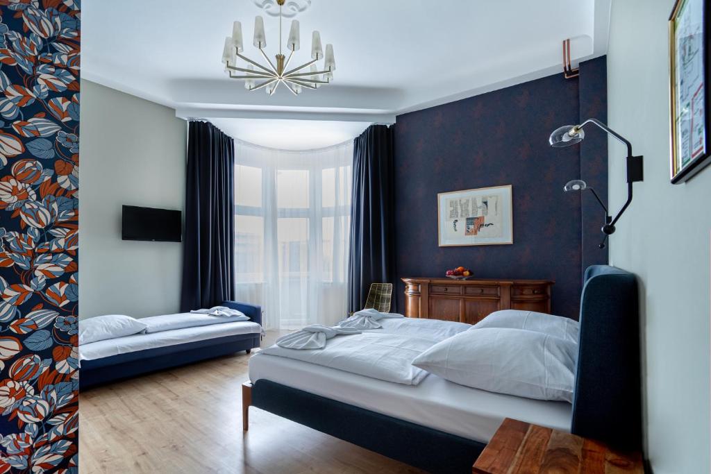 a bedroom with two beds and a chandelier at Hotel BELLEVUE am Kurfürstendamm in Berlin