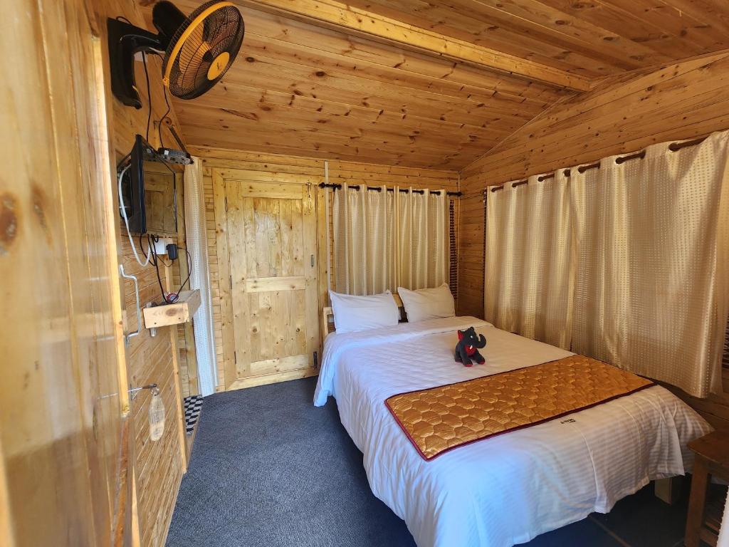 a bedroom with a bed in a wooden cabin at Wildways Mudumalai Homestay in Masinagudi