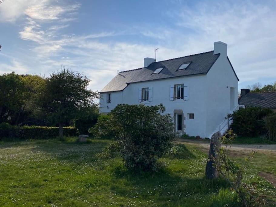 una gran casa blanca en un campo de hierba en Maison vue mer et accès plage à pied, en Clohars-Carnoët