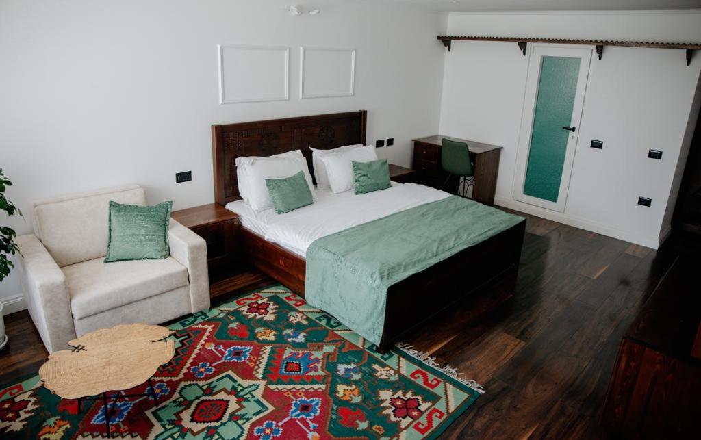 a bedroom with a bed and a chair and a rug at Hotel Thethi in Theth