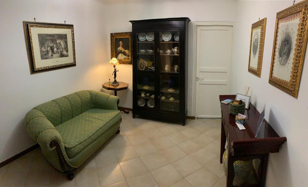 a living room with a green chair and a cabinet at La Giara in Palermo