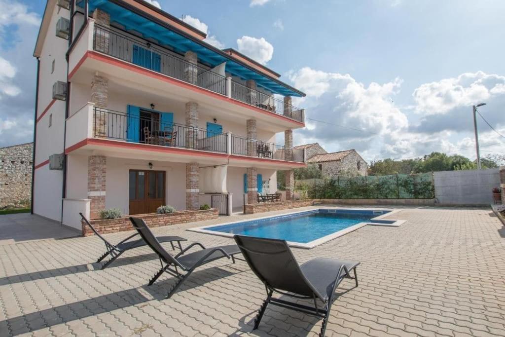 ein Haus mit einem Pool und zwei Stühlen in der Unterkunft Apartman Rocky in Petrovija