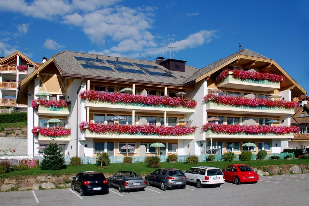 ein großes Apartmenthaus mit Blumen auf den Balkonen in der Unterkunft Residence Terentis in Terenten