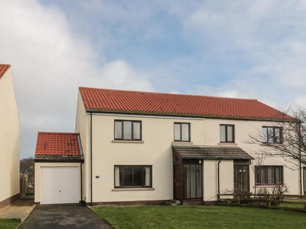 a white house with a red roof at Causeway Cottage in Berwick-Upon-Tweed