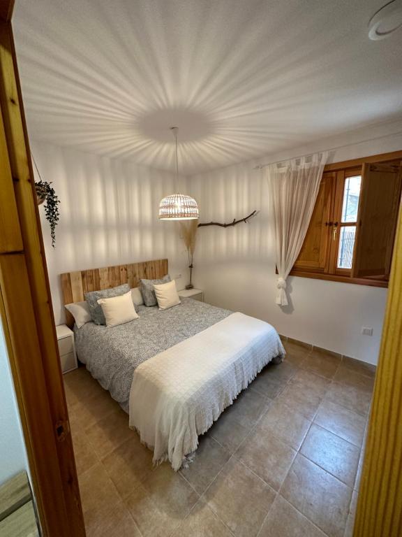 a bedroom with a bed and a chandelier at RentitSpain Puerta de la Ragua in Picena