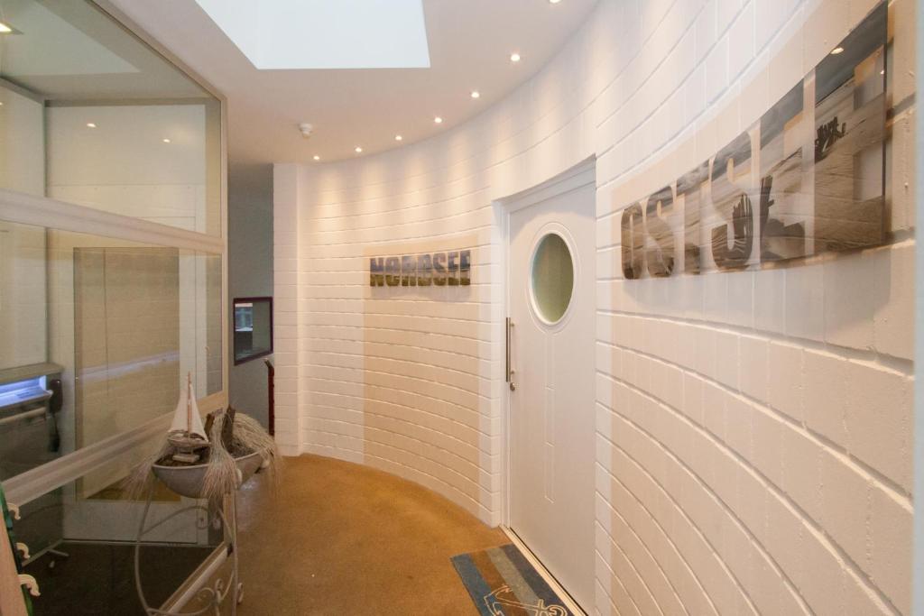 a hallway with a white brick wall and a door at Ferienwohnung Teldec in Nortorf
