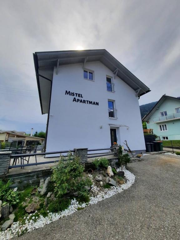 a white building with a sign on the side of it at Mistel Apartman in Bodensdorf