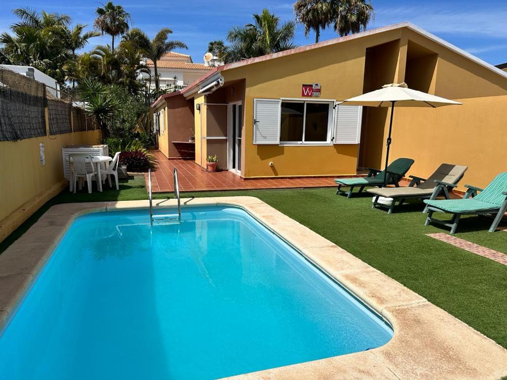 a swimming pool in the yard of a house at Casa Lube in Corralejo