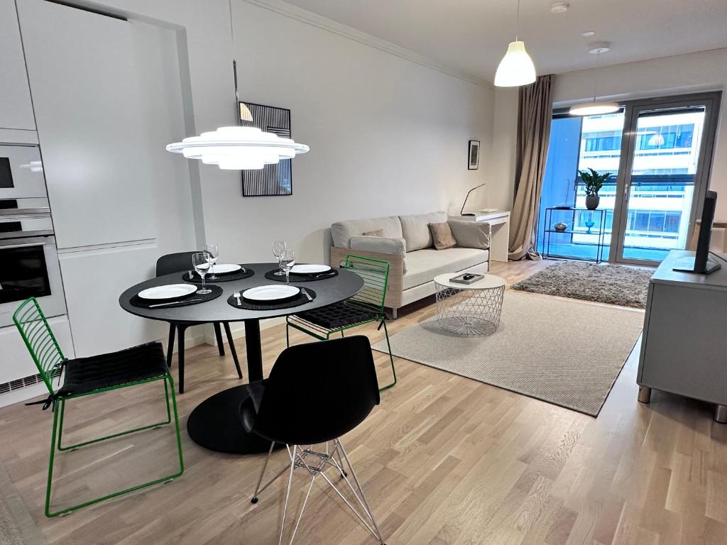 a living room with a black table and chairs at Peaceful Premium Apartment with Sauna and Balcony - Perfect Downtown Location in Tampere