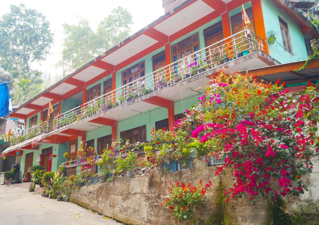 um edifício colorido com flores em frente em Yumasham Homestay em Darjeeling