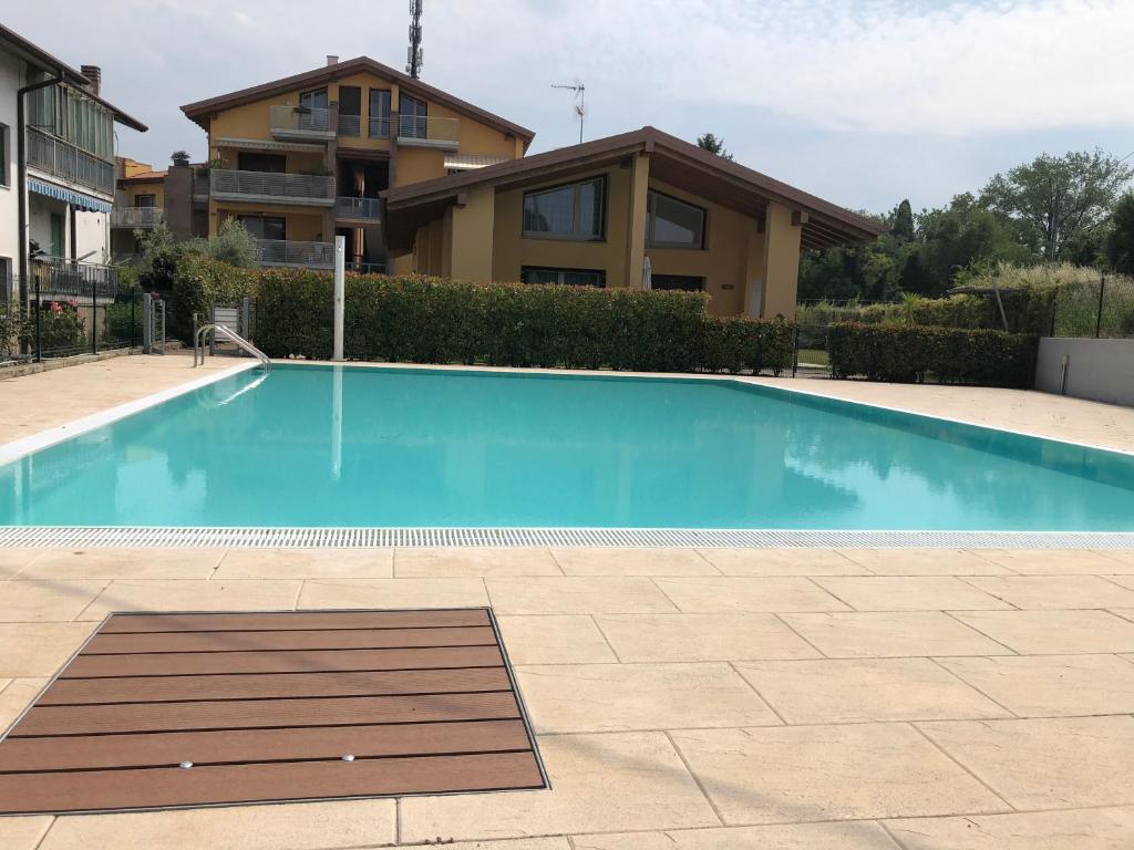 een groot blauw zwembad voor een huis bij Appartamento Borgo Secolo in Peschiera del Garda