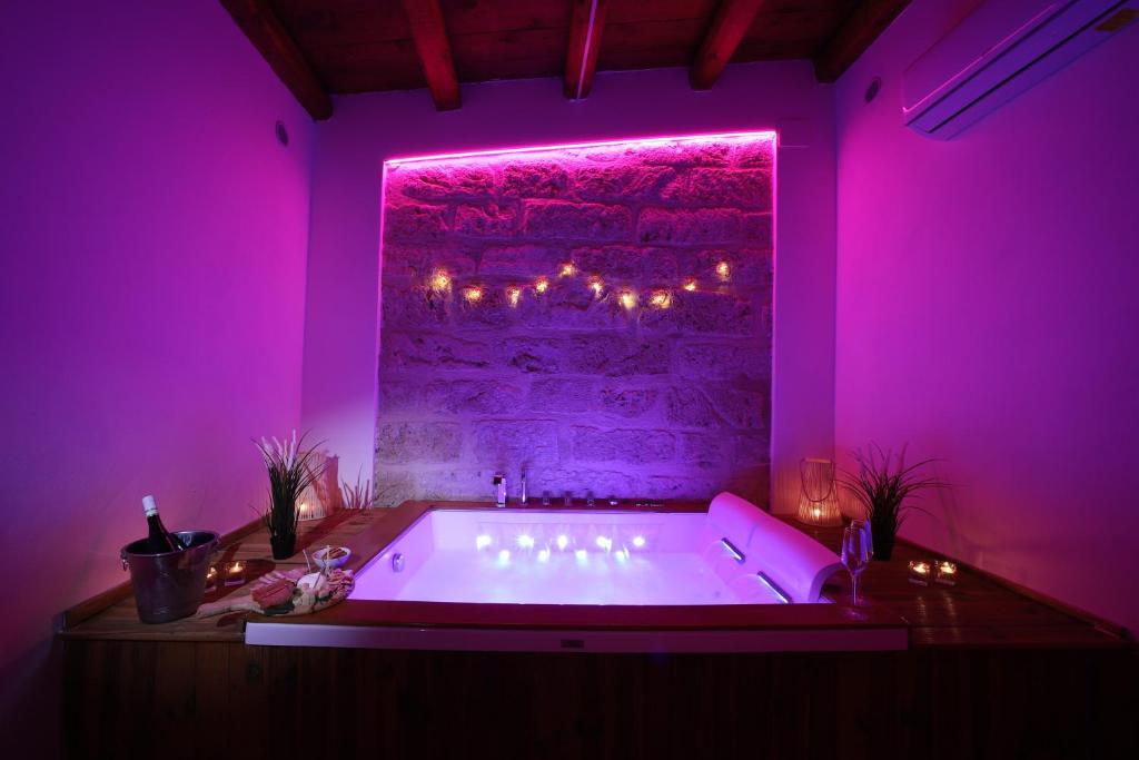 a purple bathroom with a tub with lights on it at Boscò Suites in Carini
