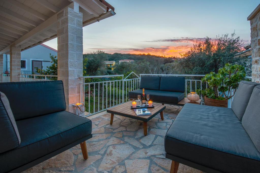 a patio with couches and a coffee table on a balcony at Vive Mar Paxos in Gaios