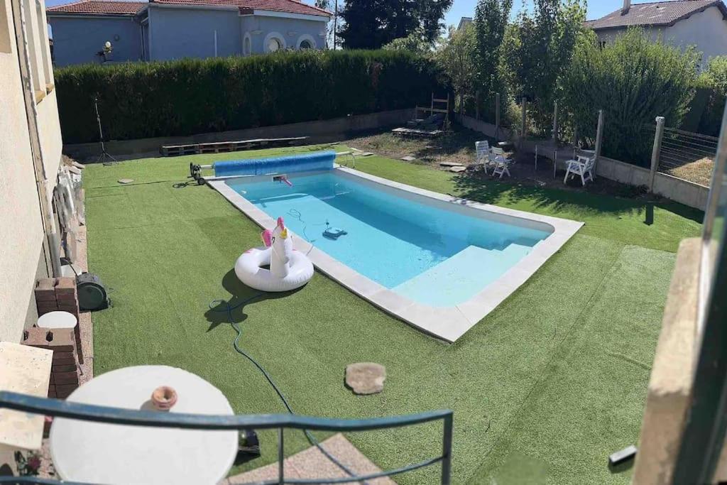 une cour avec une piscine et une pelouse dans l'établissement Villa piscine, jardin et tranquillité, à Saint-Étienne