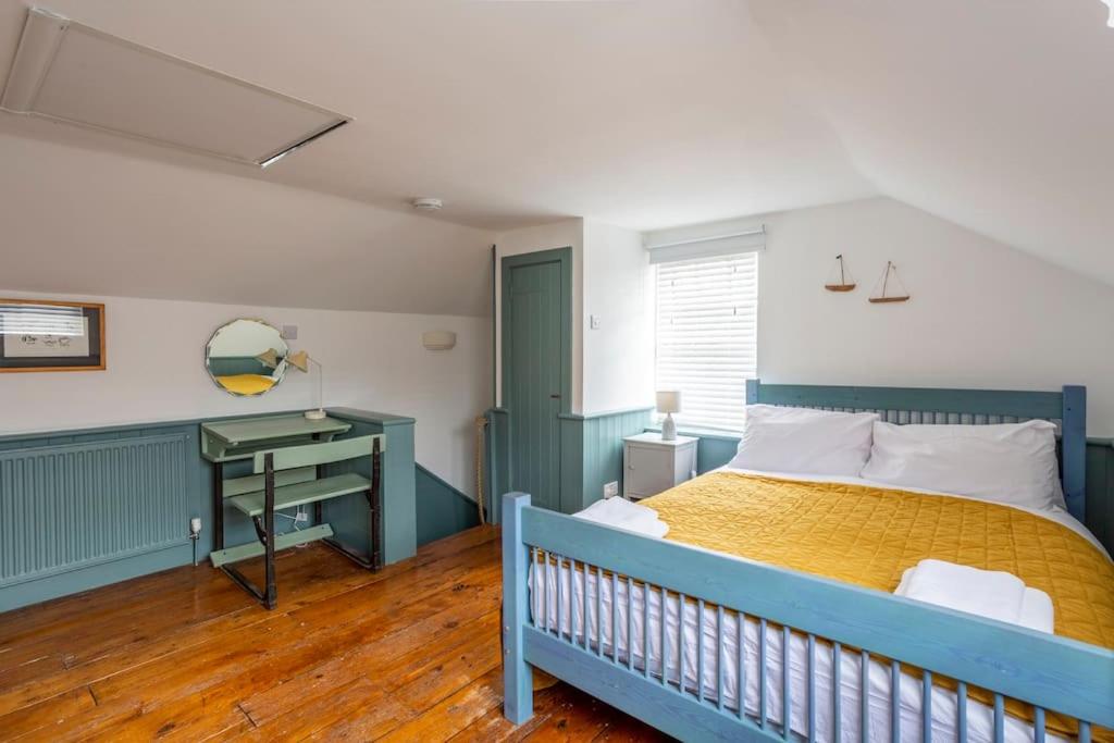a bedroom with a blue bed and a desk at Old Anchor Cottage, Broadstairs. in Broadstairs