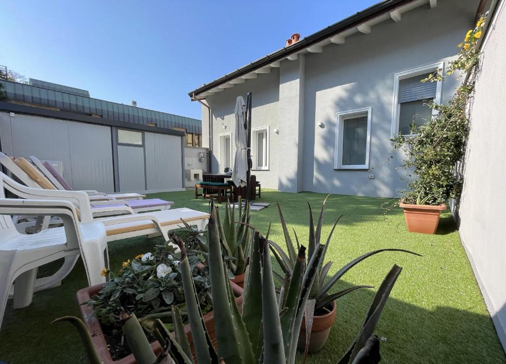 a backyard with chairs and plants and a house at Varese Apartment in Varese