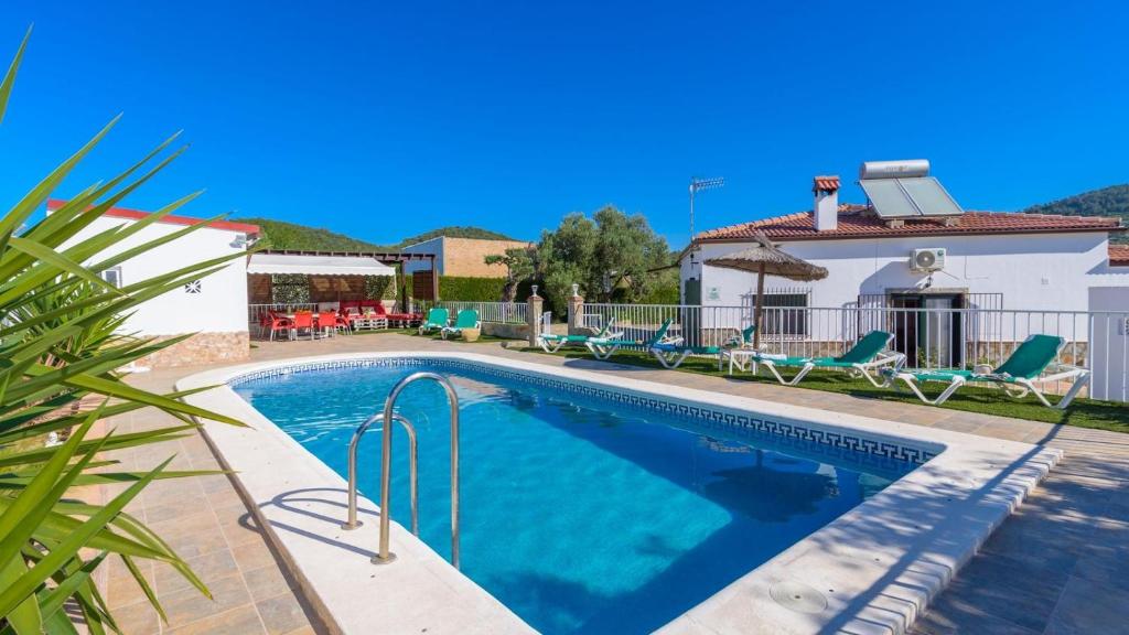 una piscina con sedie e una casa di Casa Cerrito Prado del Rey by Ruralidays a Prado del Rey