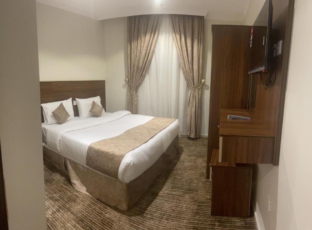 a bedroom with a large bed and a television at فندق سمى الخير in Makkah