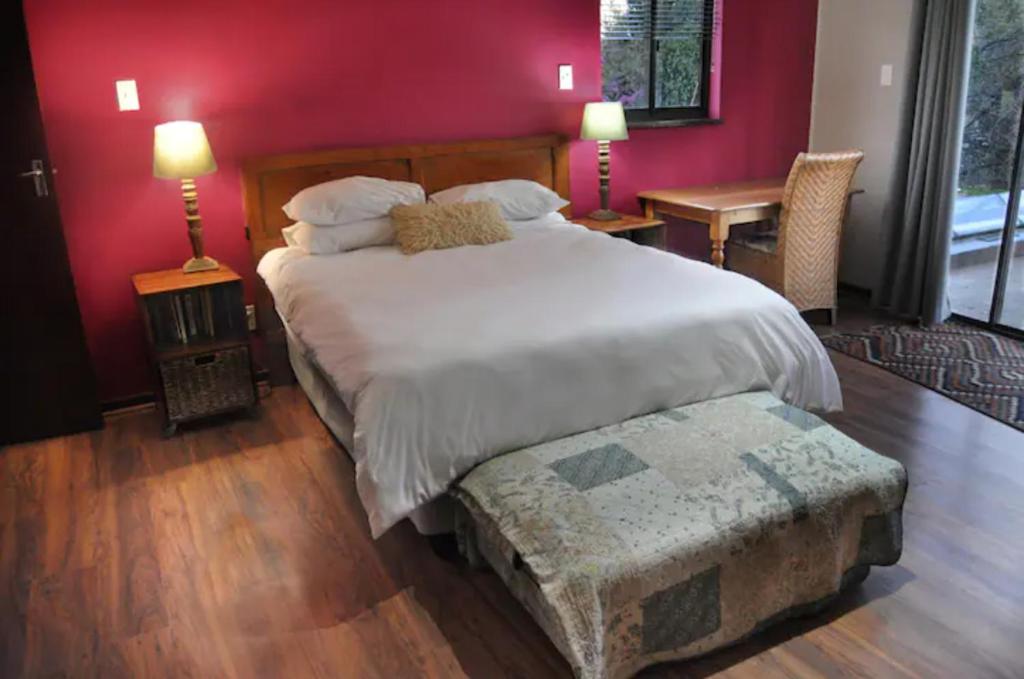 a bedroom with a large white bed and red walls at Oppikoppi in Melville in Johannesburg