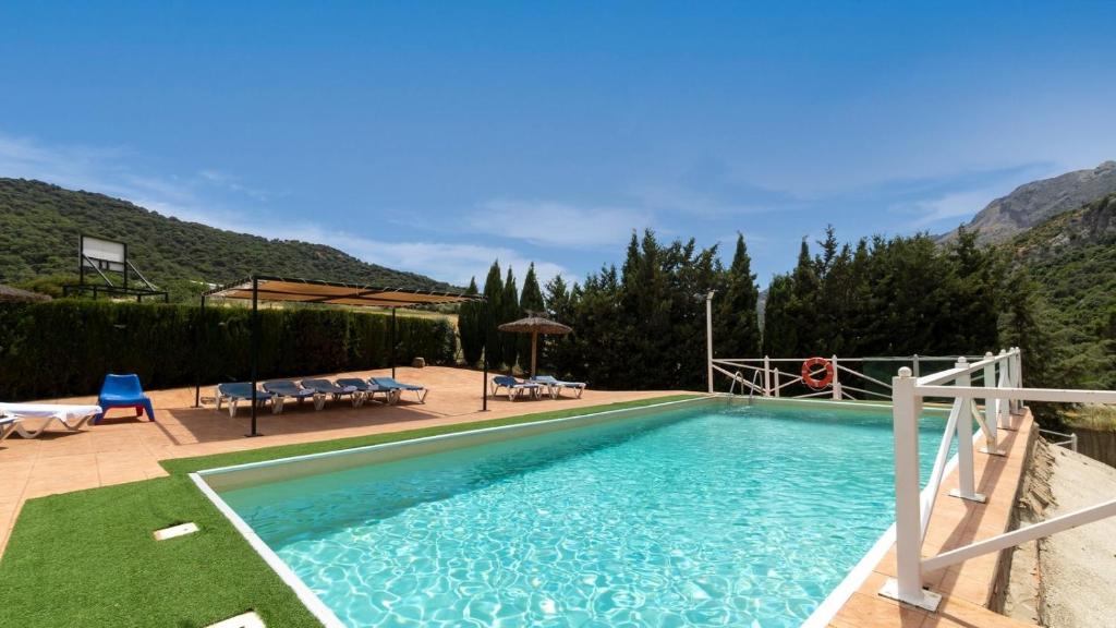 una grande piscina con sedie di Bodega Ciprés Benaoján by Ruralidays a Benaoján