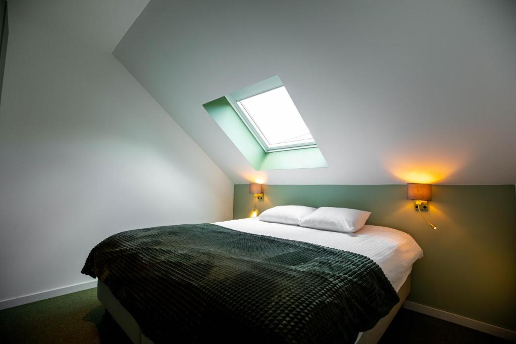a bedroom with a bed with a skylight at City Housing Genk in Genk