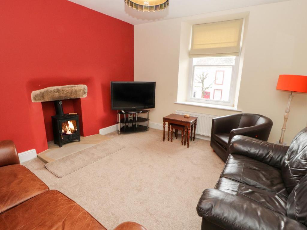 uma sala de estar com um sofá e uma lareira em Cobbleken em Cockermouth
