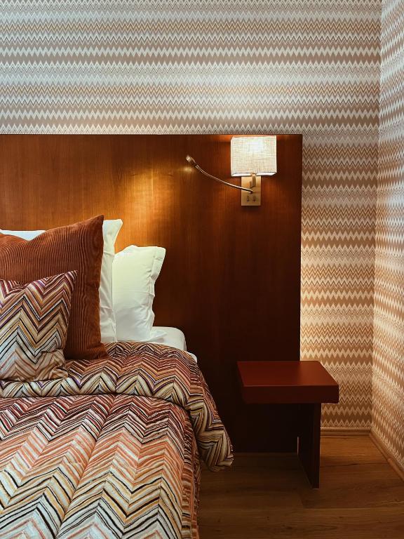 a hotel room with a bed and a lamp and a table at Hotel Van Cleef in Bruges