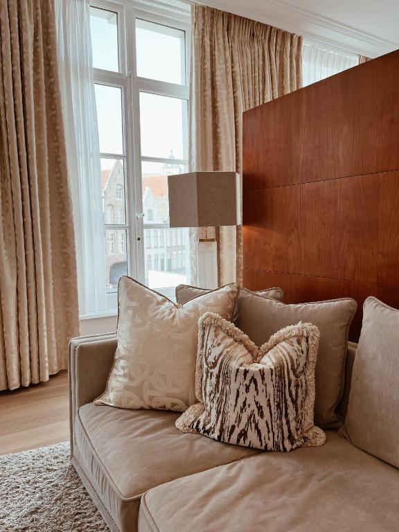 a couch with a pillow on it in a living room at Hotel Van Cleef in Bruges