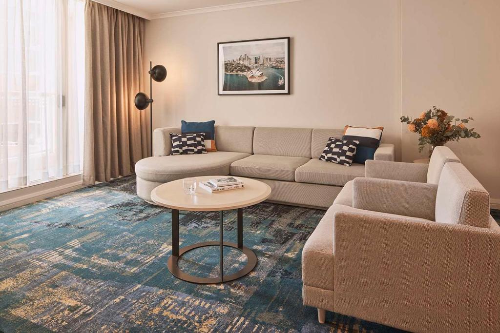 - un salon avec un canapé et une table dans l'établissement Rydges Darling Square Apartment Hotel, à Sydney