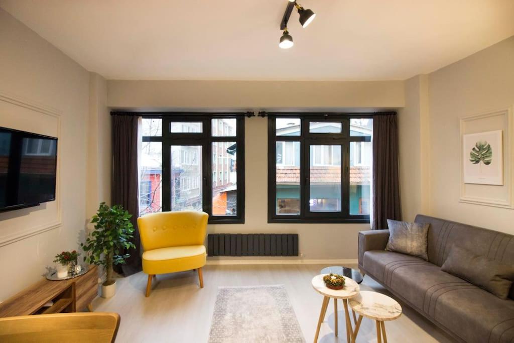 uma sala de estar com um sofá e uma cadeira amarela em Petite & Cosy 1BR Flat at the heart of Kadikoy em Istambul