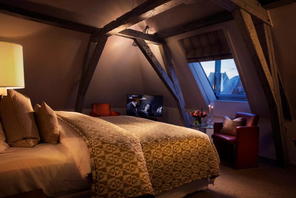 a bedroom with a bed and a window at Hotel Van Cleef in Bruges