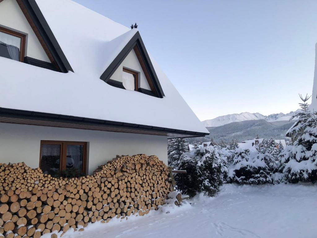 einen Haufen Feuerholz an der Seite eines Hauses in der Unterkunft Apartamenty Willa Szafran z widokiem na góry in Zakopane