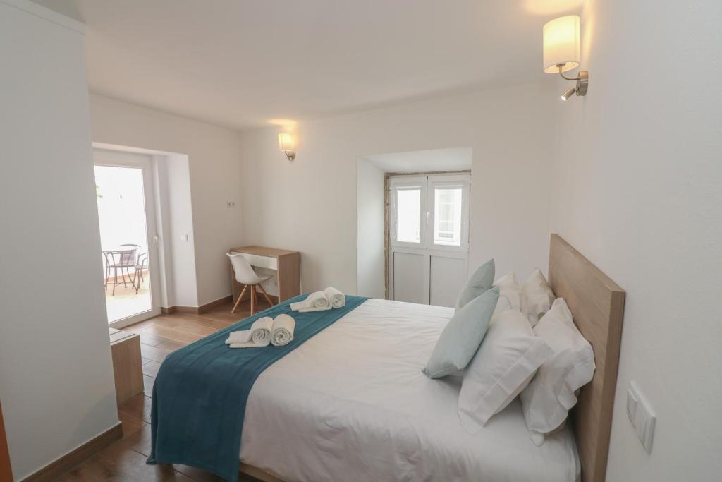 a bedroom with a bed with two towels on it at Little Break Guest House in Lagos