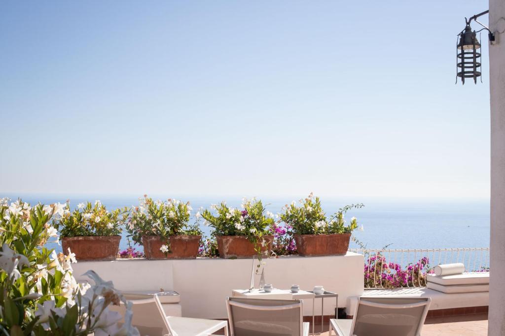 a patio with a table and chairs and the ocean at Villa Le Tuie by Elite Villas in Capri