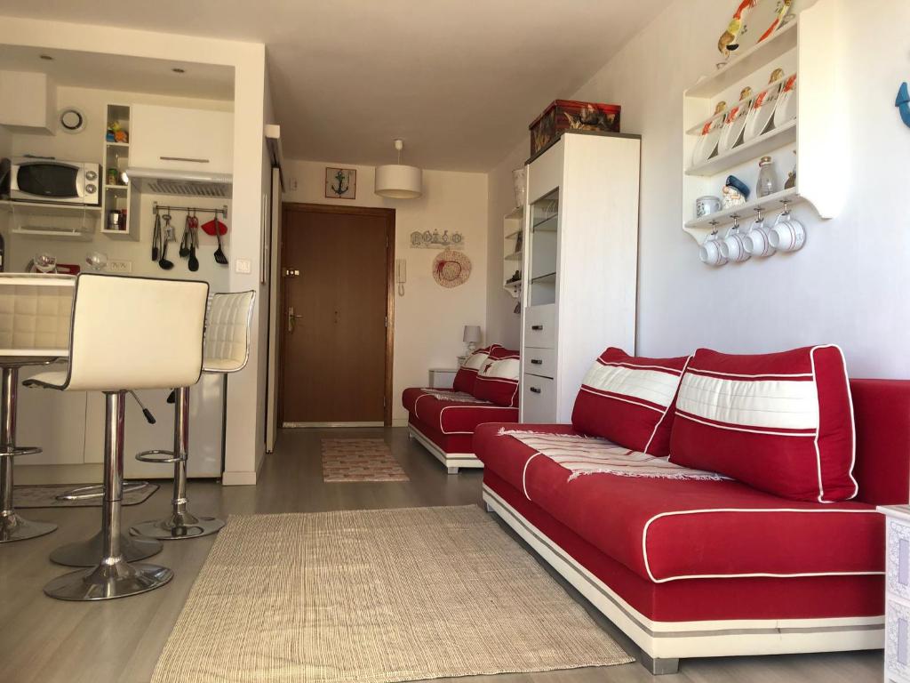 salon z czerwonymi kanapami i kuchnią w obiekcie Charmant studio à Cros de Cagnes w Cagnes-sur-Mer