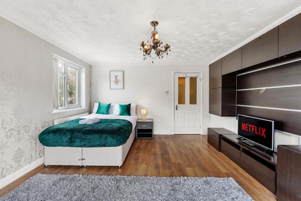 una camera con letto e TV di luxury 6 bedroom house in Aylesbury, Free parking a Buckinghamshire