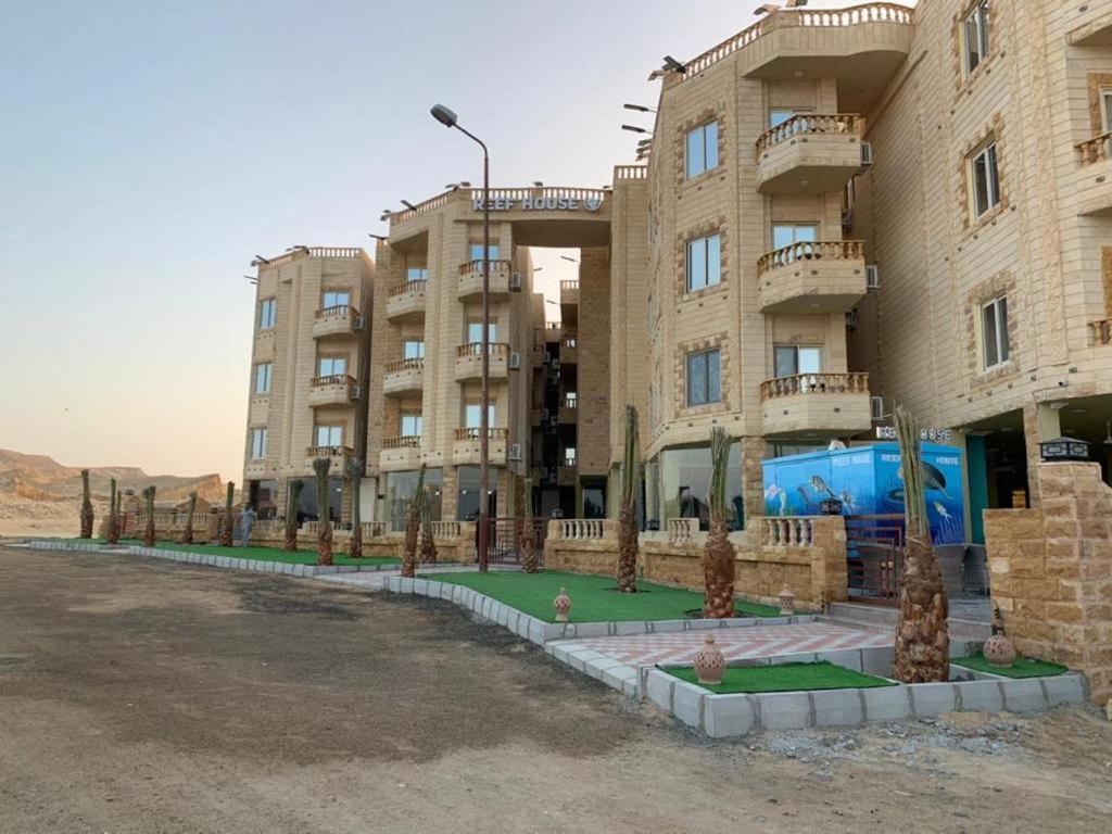 a large apartment building with a lawn in front of it at Reef House in Marsa Alam City