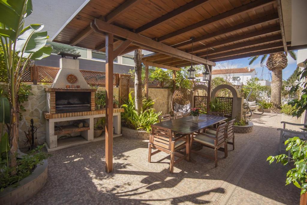 un patio con mesa y chimenea en Casa adosada con piscina comunitaria Solo familias no grupos de jovenes en Salou