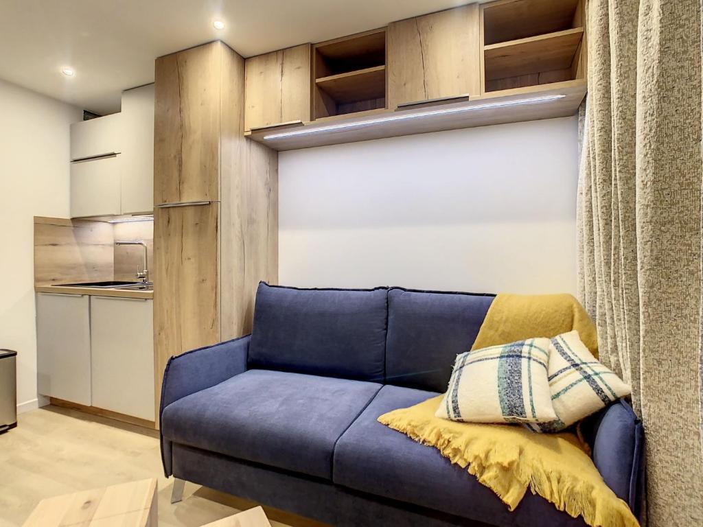 a blue couch in a room with a kitchen at Apartment Chavière 716 by Interhome in Les Menuires